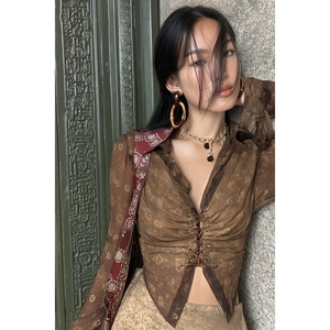 Detailed close-up of golden bamboo hoop earrings paired with a vintage patterned blouse