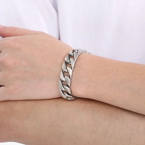 Macro close-up of matte silver stainless steel curb chain bracelet on wrist