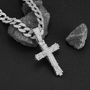 Hip hop silver Cuban link chain with iced out cross pendant on black leather background