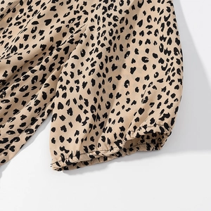 Detailed close-up of leopard print satin dress sleeve with elastic ruffled cuff design
