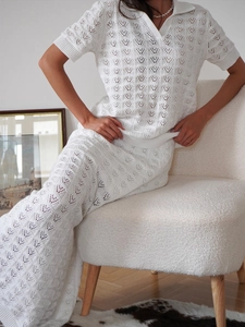 Detailed close-up of white crochet knit texture on a two-piece polo top and maxi skirt set