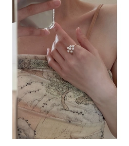 Detailed close-up of a vintage golden ring featuring a delicate pearl flower design