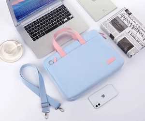 Light blue 15.6 inch laptop bag with pink handles and adjustable shoulder strap