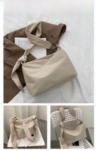 Detail of cream white canvas tote bag featuring wide knotted strap and silver chain link