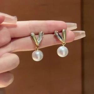 Detailed macro view of French Baroque heart metal earrings with white freshwater pearls