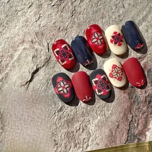 Detailed view of bohemian mandala nail stickers in red, blue and beige on stone surface