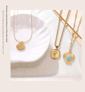 Detailed close-up of shell, sunflower and turquoise heart pendants on gold plated chains
