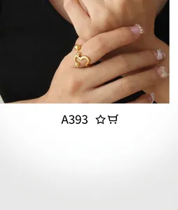 Detail of a minimalist gold wavy open ring with spherical tips worn on a finger