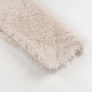 Detailed macro shot showing the soft texture of beige faux fur shawl fabric material