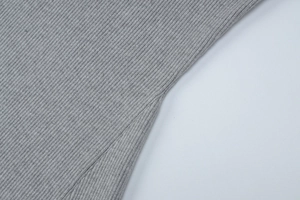 Macro shot of gray ribbed knit fabric texture and high-quality stitching on a polo dress