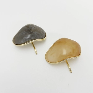 Close-up of irregular resin hair clips with marble texture and gold metallic edges