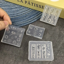Macro shot of transparent silicone nail art molds showing textured heart and gear patterns