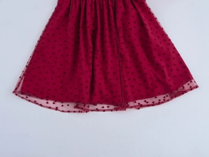Détail de la jupe de princesse en maille rouge avec motif cœur et tulle plissé