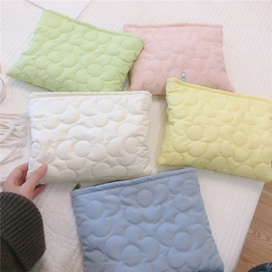 Detail of soft quilted puffer bags with floral embroidery in macaron colors