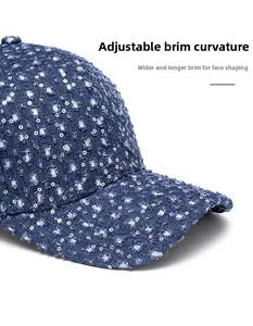 Detail of dark blue denim baseball cap with silver sequins and distressed torn design
