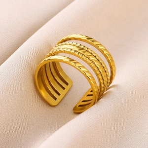 Detail of layered gold stainless steel open ring with twisted and beaded textures