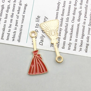 Detail of cute Halloween charms featuring red fans and skirt brooms for DIY jewelry making