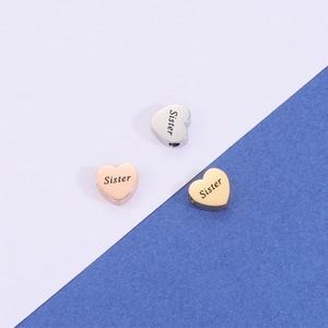 Polished stainless steel heart charms engraved with Sister in silver, gold, and rose gold