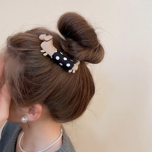 Polka dot fabric dachshund hair clip shown from a side view on a model hair bun