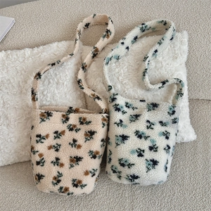 Detailed view of floral faux fur shoulder bags in beige and white leopard wool texture