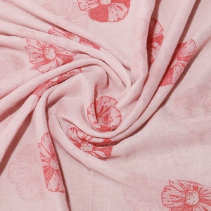 Close-up of floral print fabric showing red flowers on pink background and fine texture
