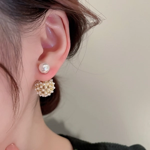 Detailed close-up of a French style gold-plated hollow sphere pearl earring worn on ear