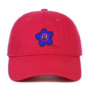 Détail de la casquette rouge en coton avec broderie de fleur bleue et violette et sourire