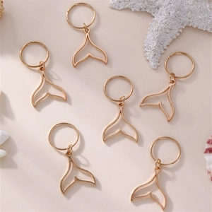 Detailed close-up of six gold metal mermaid tail charms for kids hair braid accessories