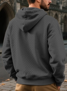 Rear view of men's dark gray hoodie featuring waffle textured fabric and a drawstring hood