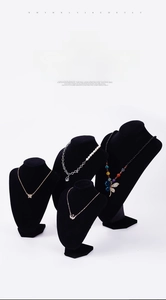 Détail de colliers sur supports en velours noir avec pendentifs en forme de papillon et cygne