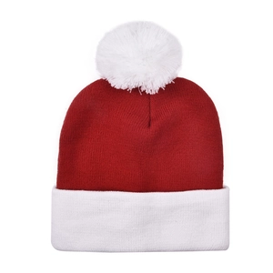 Close-up of red Christmas knit hat with thick rib texture and large white fluffy pom-pom