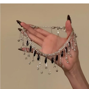 Macro detail of crystal tassel choker with elegant black teardrop pendants and silver finish