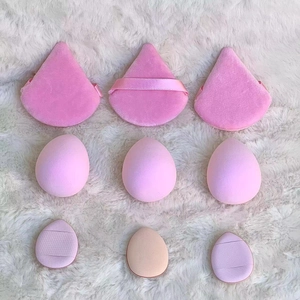 Macro shot of 9-piece pink makeup sponge set with puffs on white plush background