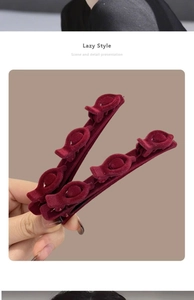 Detail showing two wine red velvet braided hair clips with three small styling sub-clips