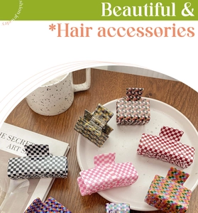 Close-up of assorted plaid checkered square hair claws and acetate shark clips on a tray