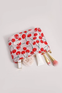 Detail of pink cherry print makeup bag with smooth metal zipper and brand woven label