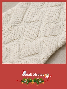 Close-up of cream white knitted Christmas stocking showing thick cable knit diamond pattern