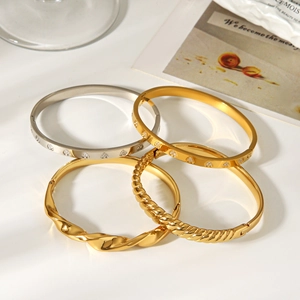 Détail de joncs torsadés et bracelets cœur en cristal avec finitions or et argent