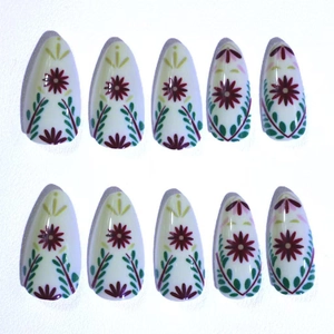 Almond press-on nails with white base and retro burgundy floral daisy patterns