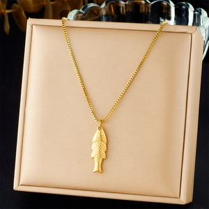 Detailed close-up of a golden fish pendant with scale textures on a box chain