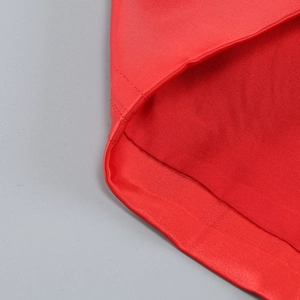 Macro shot of red satin fabric featuring twill texture and durable double-stitched hem detail