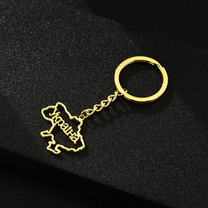 Detail of a golden Ukraine map keychain with Ukraina engraving on black background