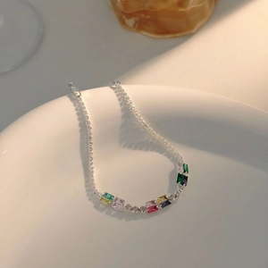 Close-up of vibrant rectangular colorful gemstones on a silver chain link bracelet