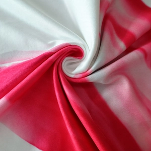 Close-up detail of red and white tie-dye swirl pattern on elastic polyester fabric