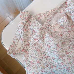 Primer plano de un bolso de algodón con estampado de flores rosas y amarillas.