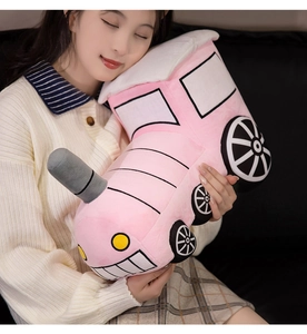 Detailed view of a soft pink cartoon plush train pillow held by a female model