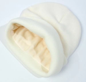 Close-up of white knit beanie showing thick thermal fleece lining for winter warmth