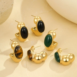 Three pairs of vintage C-shape earrings with emerald, black, and tiger eye stones