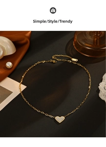 Macro detail of a 14K gold-plated heart pendant on a rectangular link chain