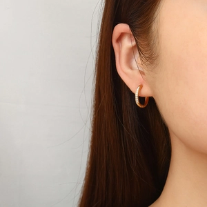 Elegant gold titanium steel hoop earring with sparkling rhinestones worn by a model